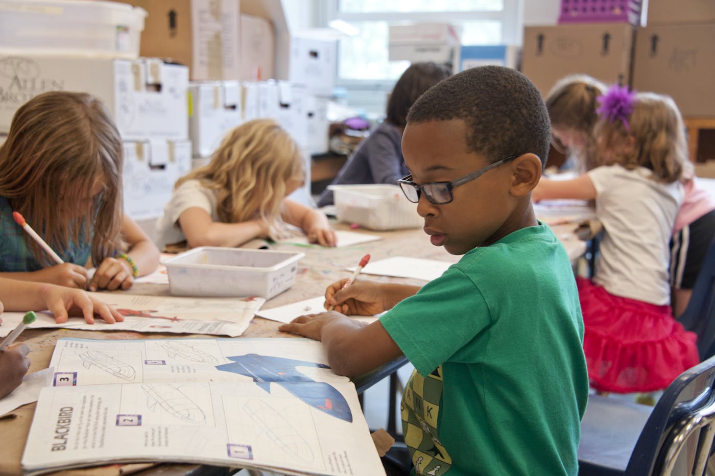 A student smiling gently with a hand on heart during quiet reflection